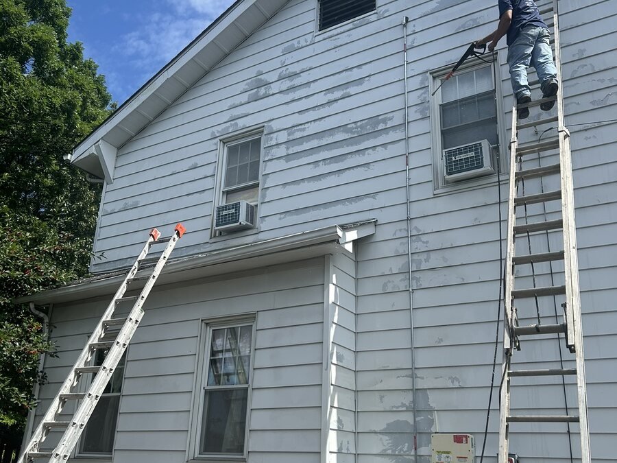 Trabajo de pintura exterior en el revestimiento superior de una vivienda