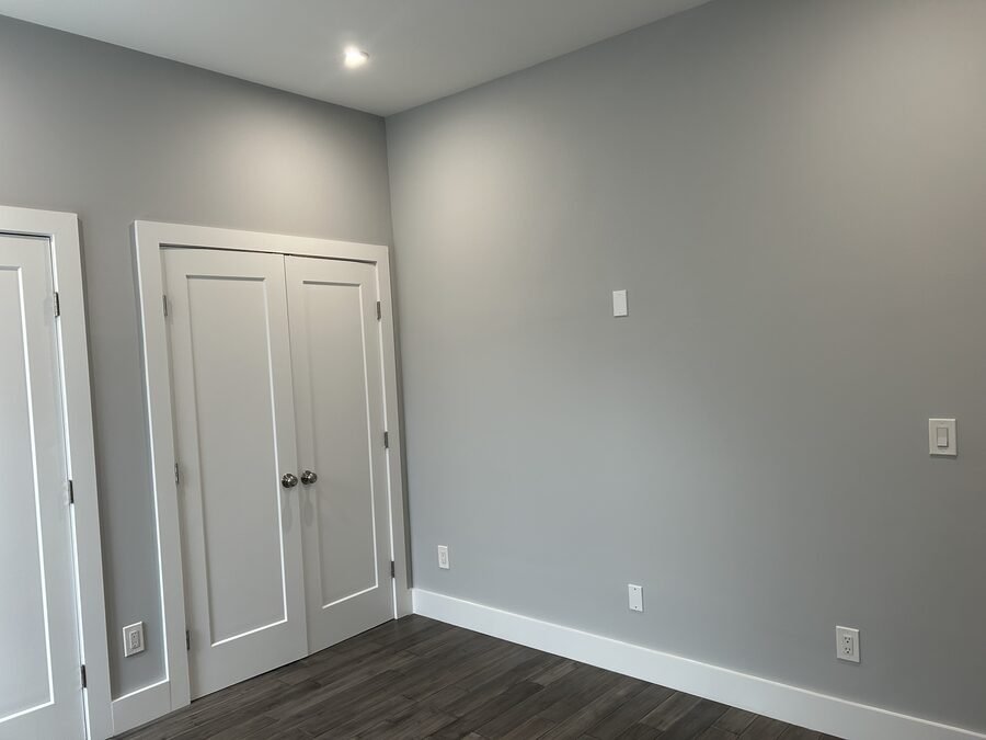 Completed gray room with trim, doors, flooring, and outlets
