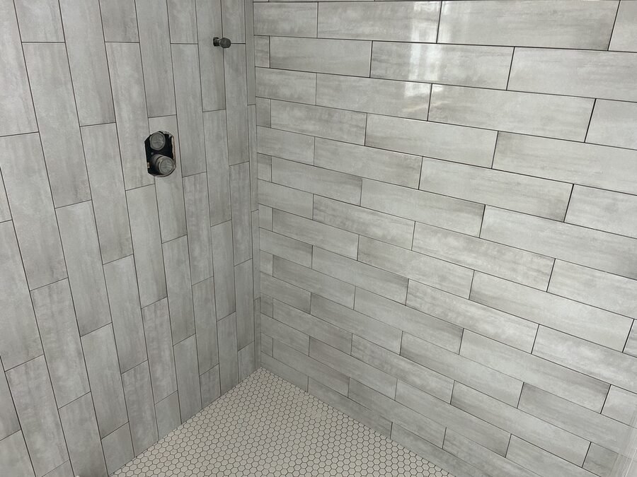 Gray tile shower wall and niche during bathroom tile work