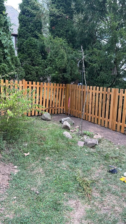 Wood fence installation along a yard
