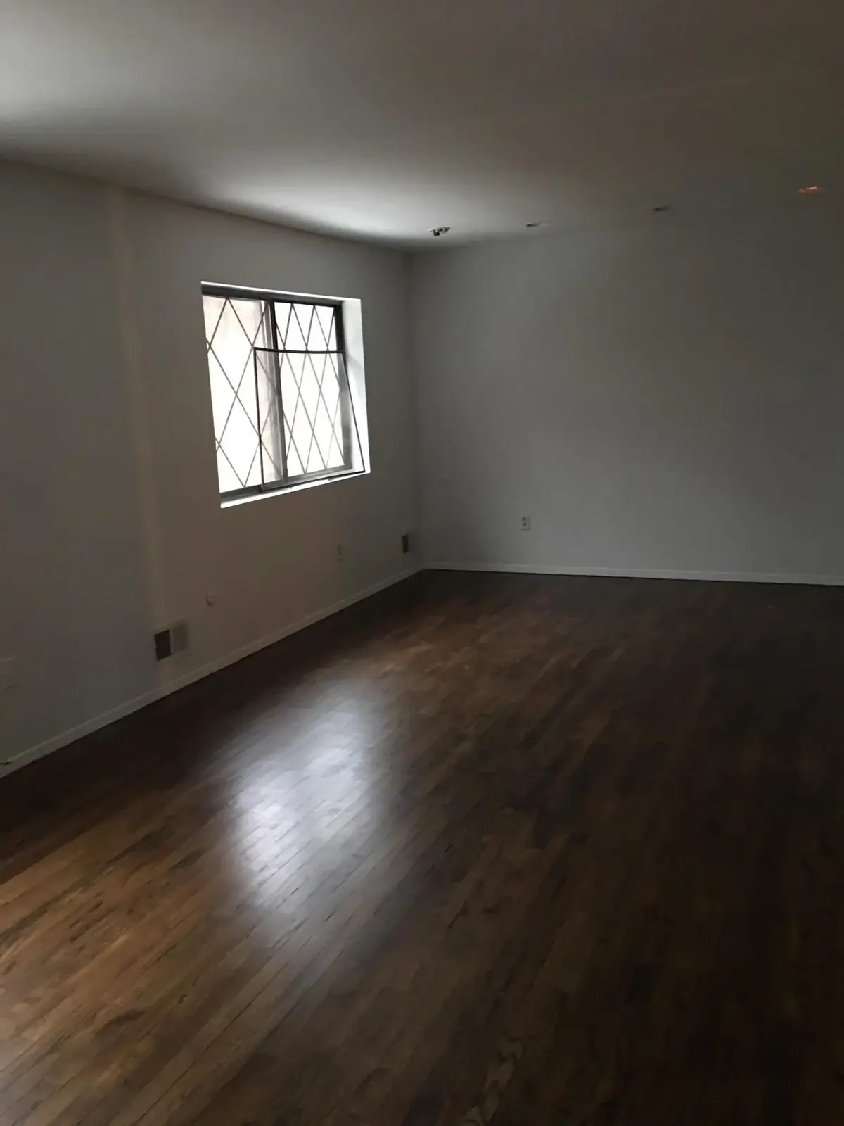 Finished interior room with dark flooring, bright walls, and clean trim