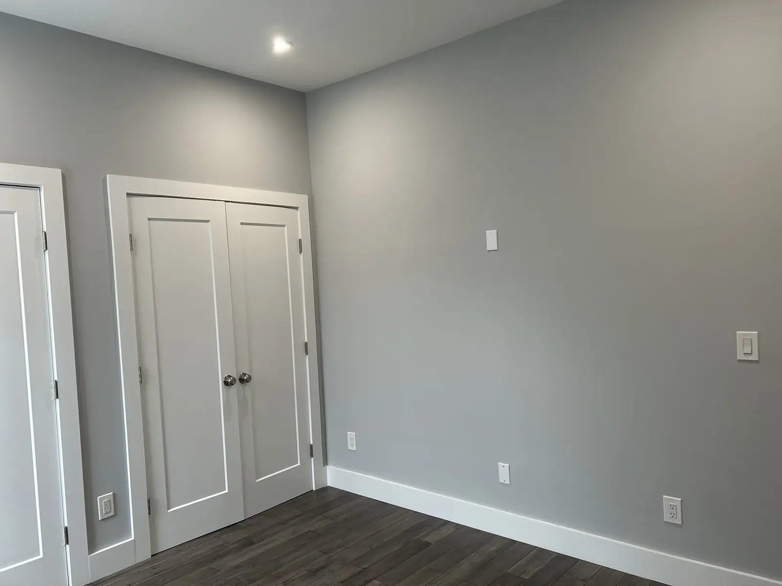 Completed gray room with trim, doors, flooring, and outlets