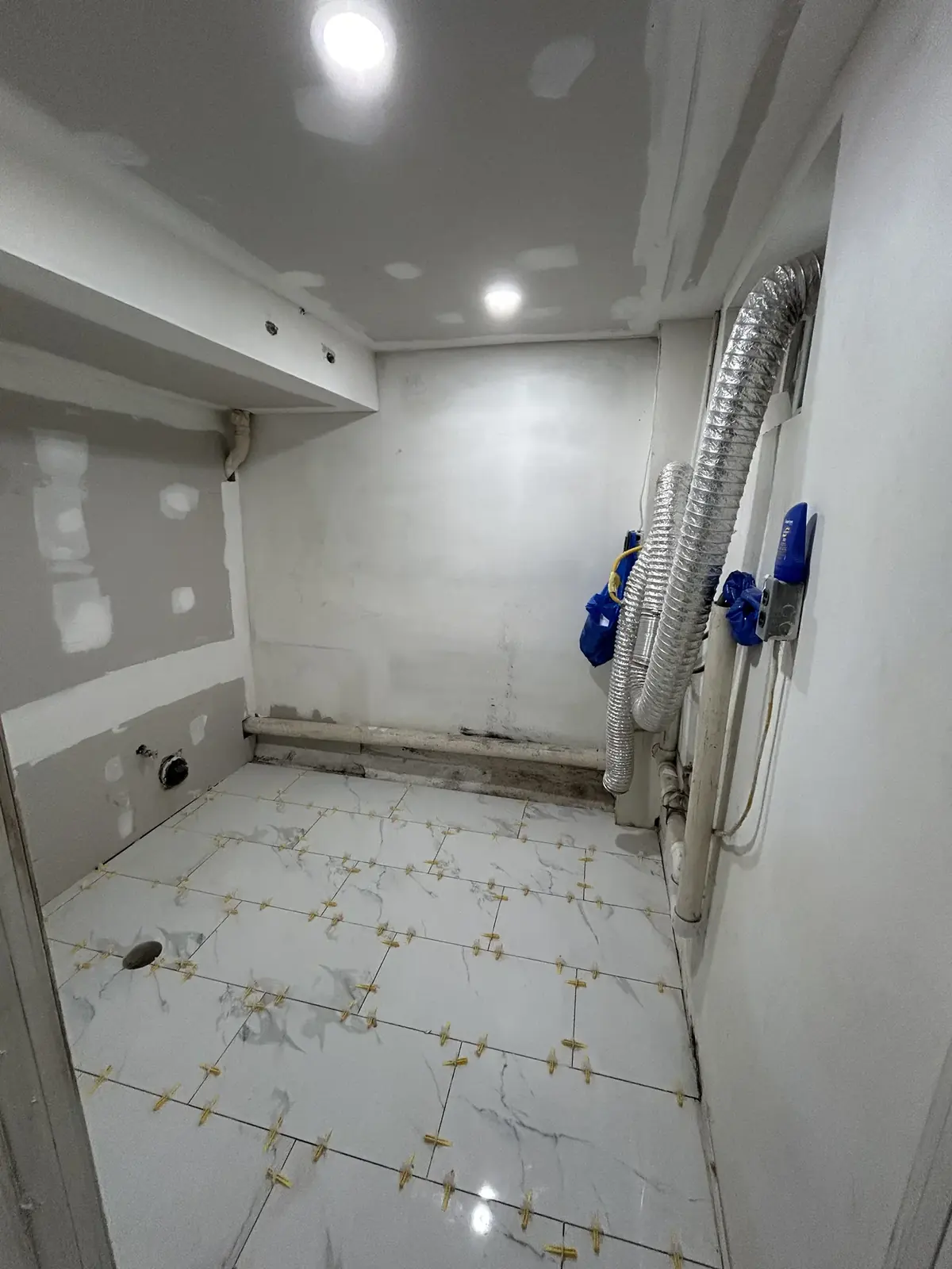 Bathroom or laundry rough-in with drywall patches and plumbing lines