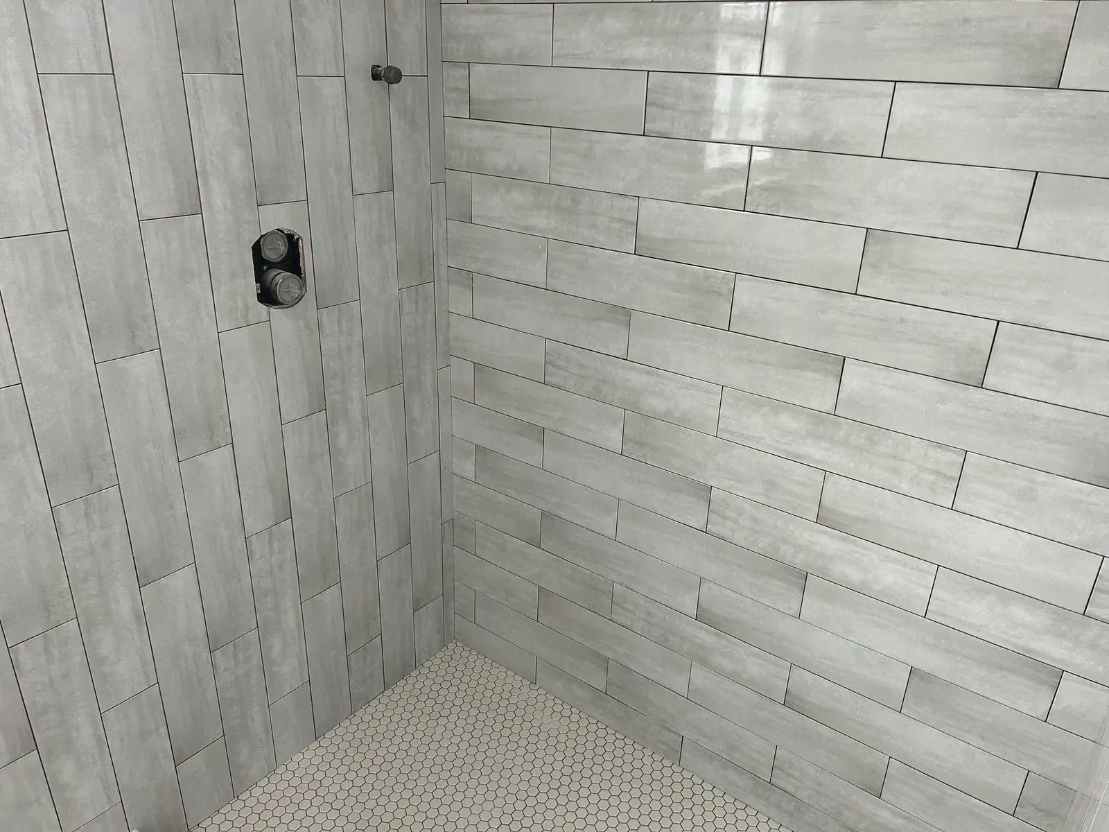 Grey shower wall tile with niche during tile installation